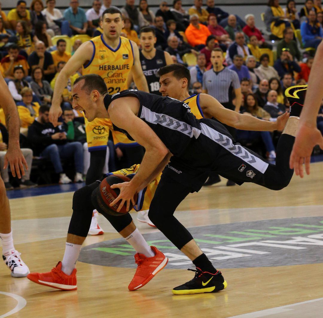 El jugador del Herbalife Gran Canaria Fabio Santana y el jugador del Retabet Bilbao Basket Jonathan Rouselle caen durante el partido de la liga ACB que ambos equipos disputaron este domingo en el Gran Canaria Arena, en Las Palmas de Gran Canaria.