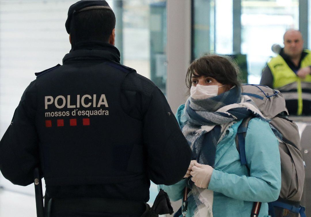 Un agent dels Mossos d'Esquadra identificant a una dona per no complir el confinament