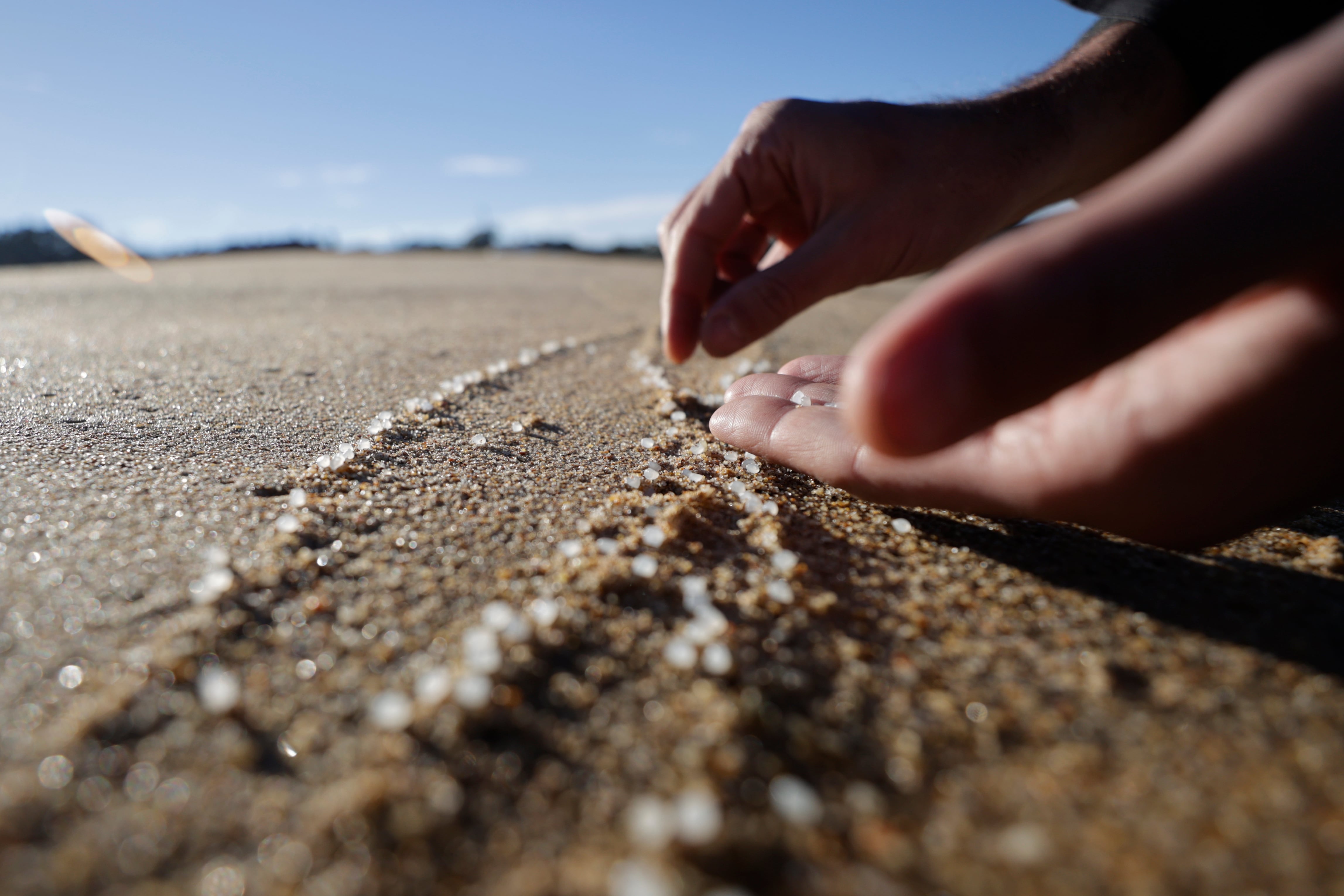 -FOTODELDIA- OLEIROS (A CORUÑA), 12/01/2024.- Una persona recoge pellets este viernes, en la playa de Mera, situada en el concello coruñés de Oleiros, en una jornada en la que continúa la llegada a los arenales gallegos de estas pequeñas esferas de plástico tras la caída de un contenedor del buque Toconao el pasado mes de diciembre. EFE/Cabalar
