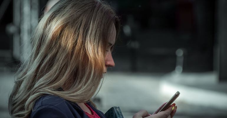 Una mujer con un teléfono en la mano.