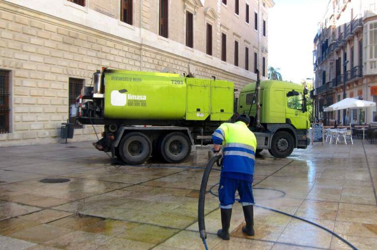 Un operario de Limasa baldea una calle en el centro de Málaga