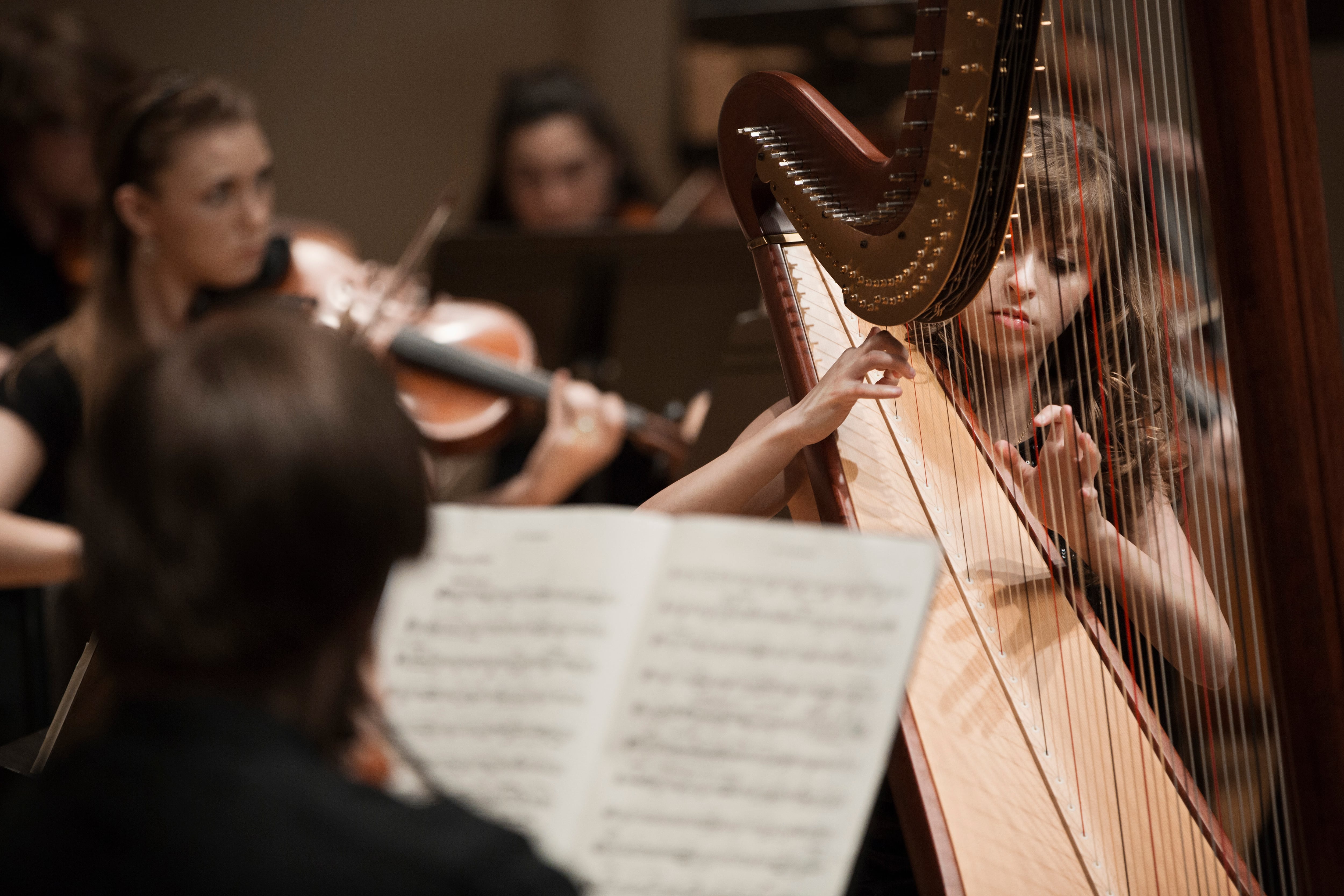 Mujer tocando el arpa en una orquesta