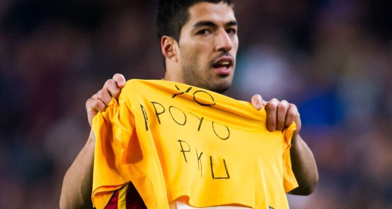Luis Suarez muestra una camiseta de de apoyo a los pacientes de PKy durante el partido de ante el Sporting Gijón