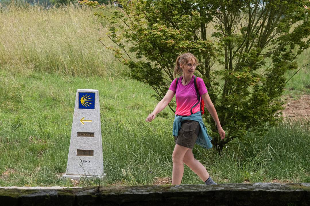 Archivo - Una peregrina camina en la última etapa del camino de Santiago, a 26 de junio de 2021, en Santiago de Compostela