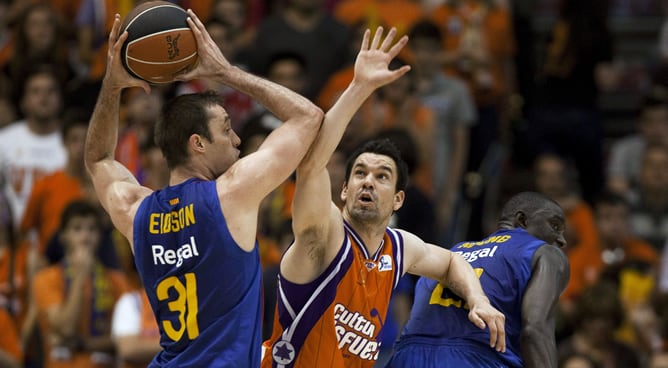 El alero estadounidense del FC Barcelona Regal, Chuck Edison, conduce el balón frente al escolta del Valencia Basket, Rafa Martinez, durante el cuarto partido de Play Off de semifinales de la Liga ACB de baloncesto que se disputa este viernes en el pabell