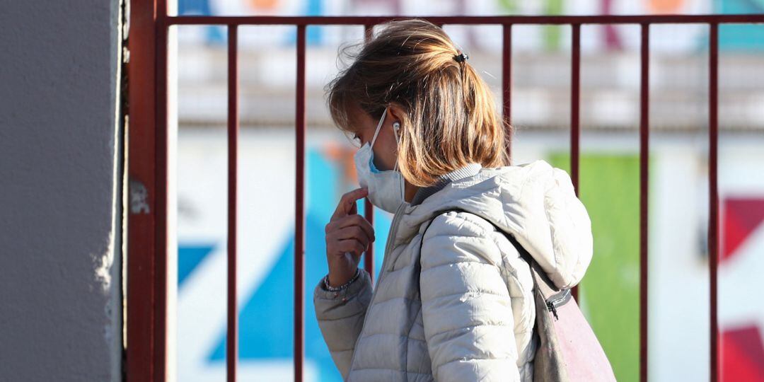 Una mujer con una mascarilla por una calle de Madrid.