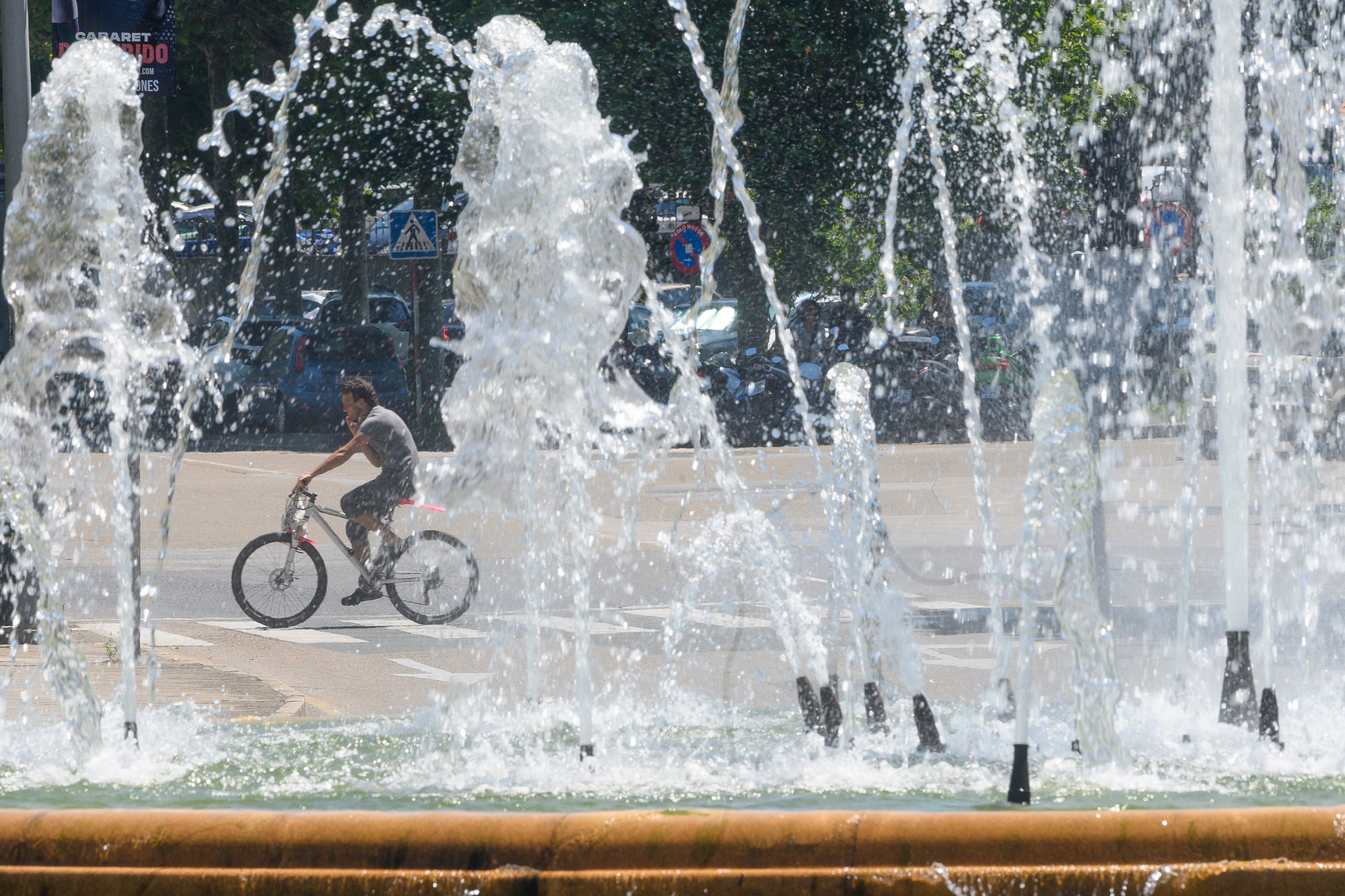 Un hombre circula en bicicleta por El Sardinero, en una jornada de altas temperaturas en la capital cántabra. EFE/Pedro Puente Hoyos