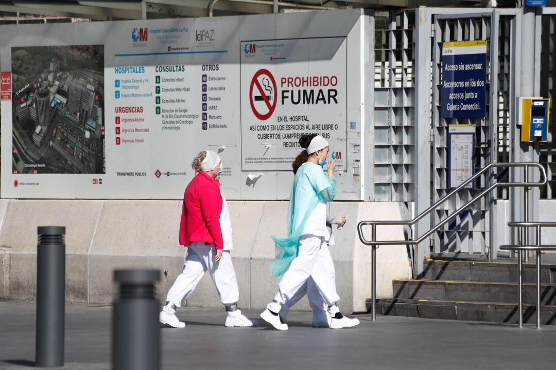 Dos sanitarias protegidas con mascarillas se dirigen a la entrada del Hospital La Paz, centro en cuyas dependencias se ha instalado una carpa que sirve como ampliación de las Urgencias del centro y donde se atiende a pacientes sospechosos de coronavirus.