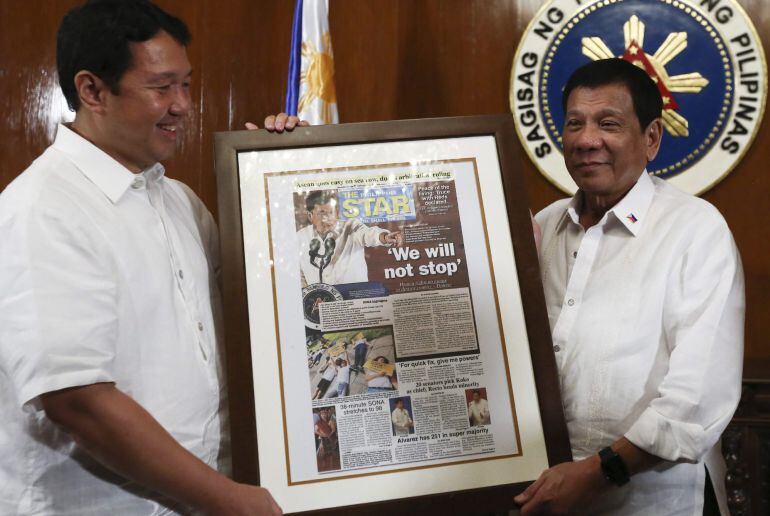 Fotografía facilitada hoy, 4 de agosto de 2016, por el gobierno filipino que muestra al presidente Rodrigo Duterte (d) y al presidente del periódico Philippine Star, Miguel Belmonte (i), que sostienen una primera página del diario con el titular &quot;No parar