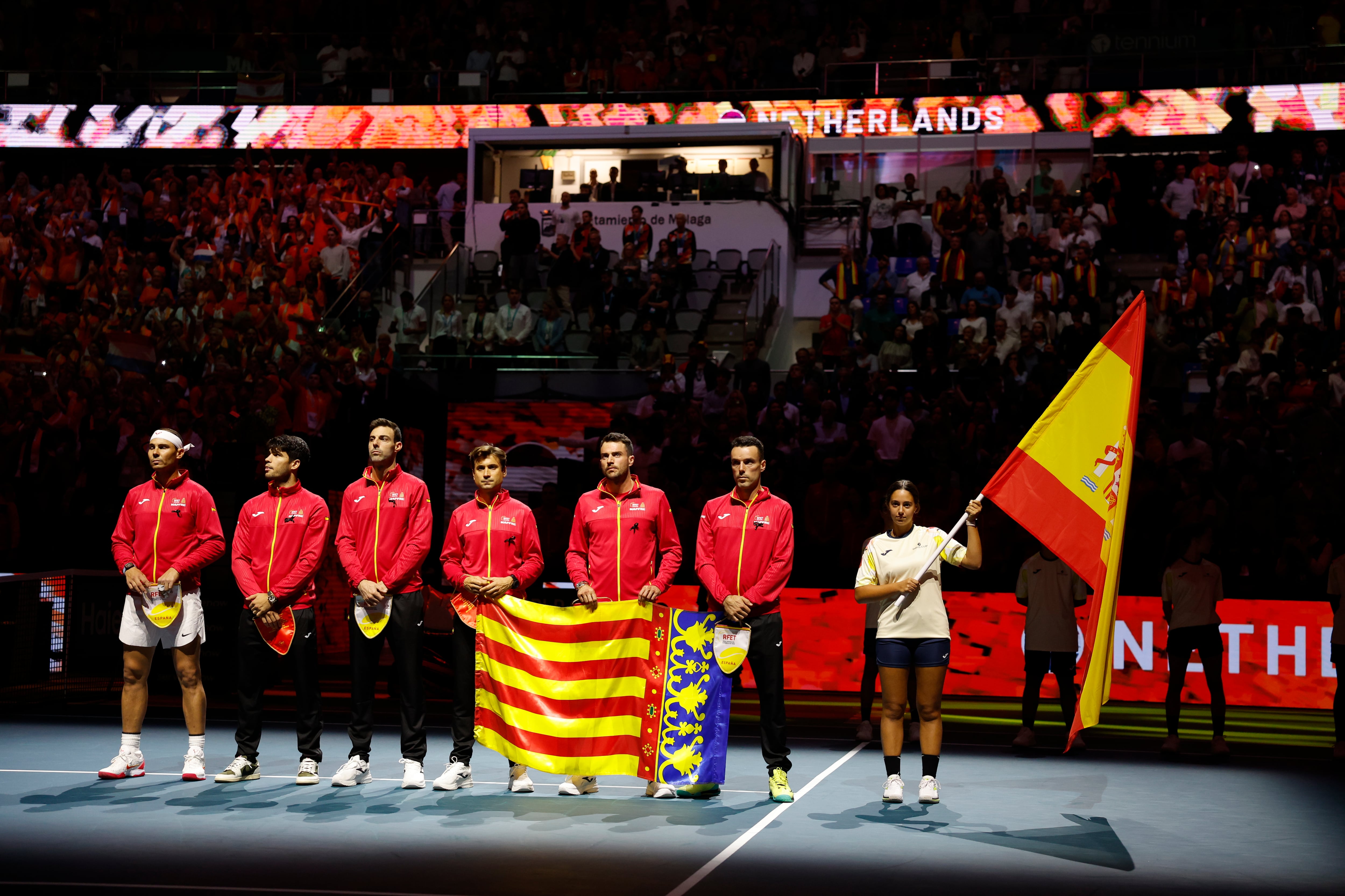 GRAFAND4866. MÁLAGA, 19/11/2024.- El equipo español, capitaneado por David Ferrer, con Rafael Nadal, Carlos Alcaraz, Roberto Bautista, Marcel Granollers y Pedro Martínez, con la bandera de la Comunidad Valenciana durante el minuto de silencio que se ha guardado en memoria a las víctimas de las inundaciones en Valencia, momentos antes de comenzar las Finales de la Copa Davis que abren los equipos de España y Países Bajos, este martes en Málaga, en el Palacio de los Deportes José María Martín Carpena.EFE/Jorge Zapata
