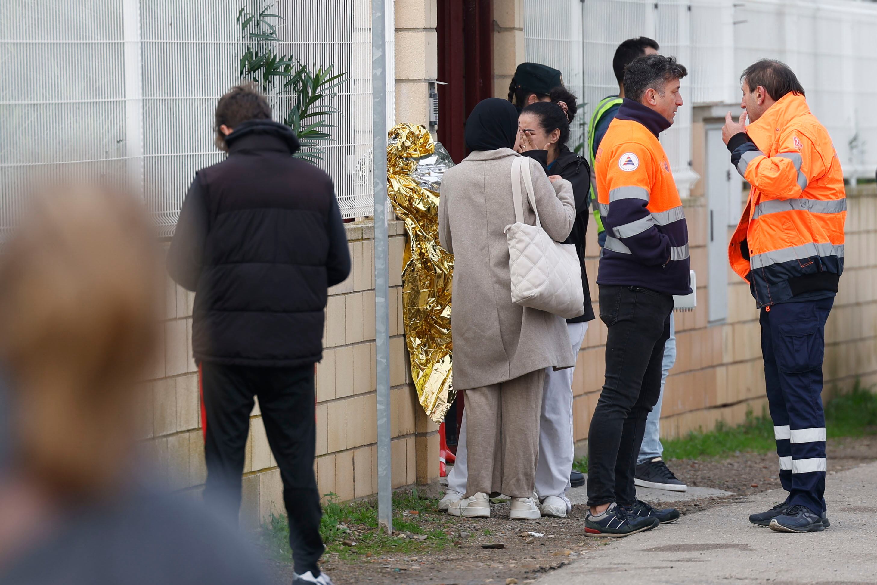 VILLAFRANCA DE EBRO (ZARAGOZA), 15/11/2024.- Miembros de los servicios de emergencia y familiares de residentes a las puertas de una residencia de mayores en Villafranca de Ebro, este viernes. El incendio declarado esta madrugada en una residencia de mayores de Villafranca de Ebro (Zaragoza), en el que han muerto diez personas, se desarrolló en un ala del edificio, de una sola planta, y provocó gran cantidad de humo, saturando prácticamente todo el recinto. Además de las diez víctimas mortales, al parecer por inhalación de humo, otras dos personas han resultado heridas y han sido trasladadas en estado crítico al hospital Royo Villanova. EFE/ Javier Cebollada
