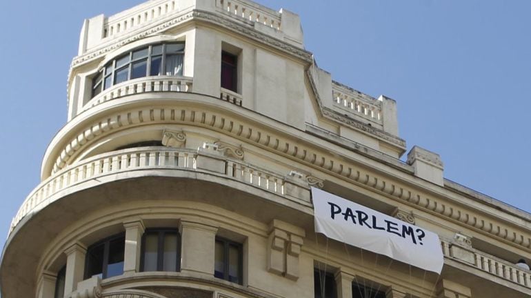 Pancarta con el lema &#039;¿Hablemos?&#039; en un edificio de la Gran Vía de Madrid.