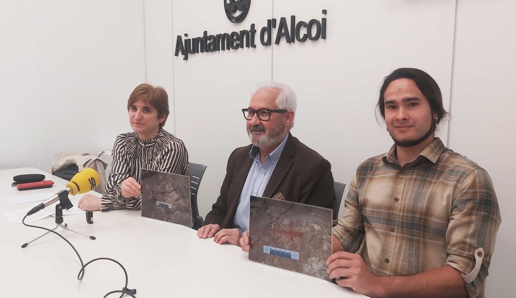 Palmira Torregrosa, Ignacio Trelis y Kevin Batán, en la sala de prensa del Ayuntamiento con dos imágenes de las pinturas halladas
