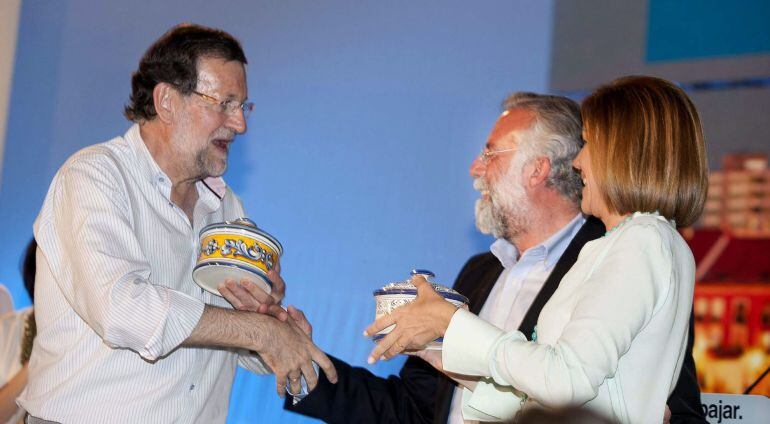 Rajoy recibe una cerámica de regalo de manos del alcalde de Talavera y candidato a la reelección, Jaime Ramos, en presencia de la candidata a la reelección a la presidencia de Castilla-La Mancha, María Dolores de Cospedal, durante un mitin celebrado en Talavera.