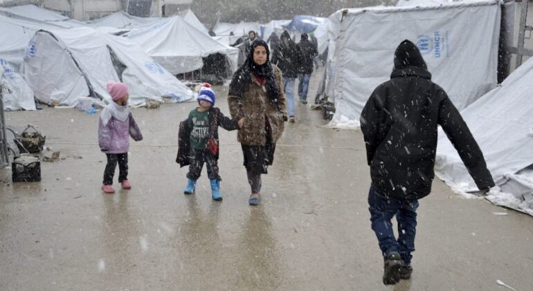 Varios refugiados caminan bajo la nieve en el campamento de refugiados de Moria, en la isla de Lesbos (Grecia).