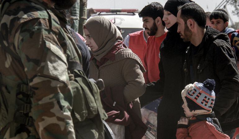 Un grupo de civiles son evacuados de Guta Oriental a través de un corredor seguro a campamentos de refugiados en la zona rural de Damasco (Siria).