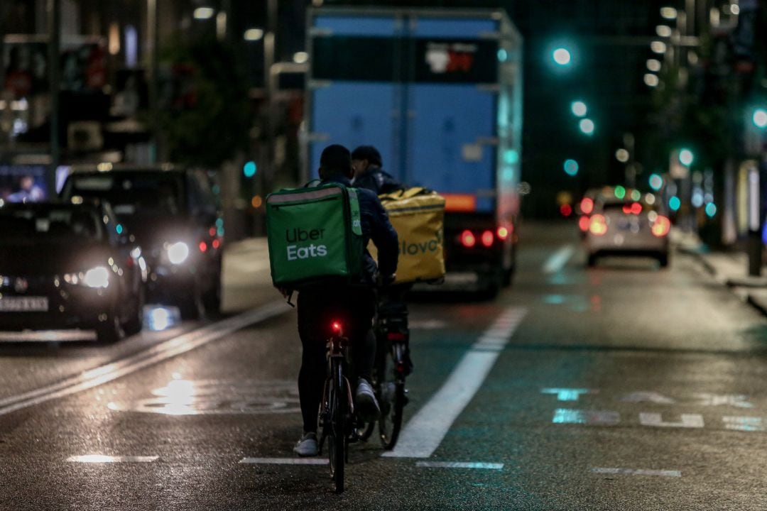 Un rider de Glovo y otro de Uber Eats.