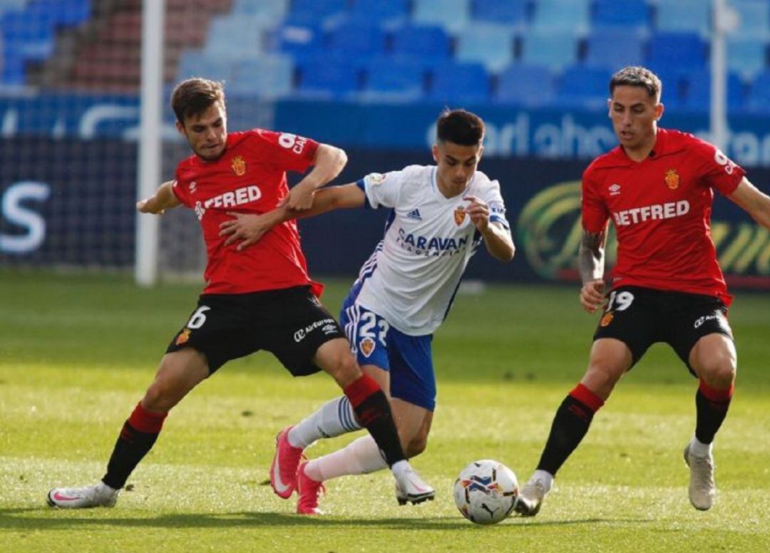Bermejo lucha por un balón frente a dos rivales