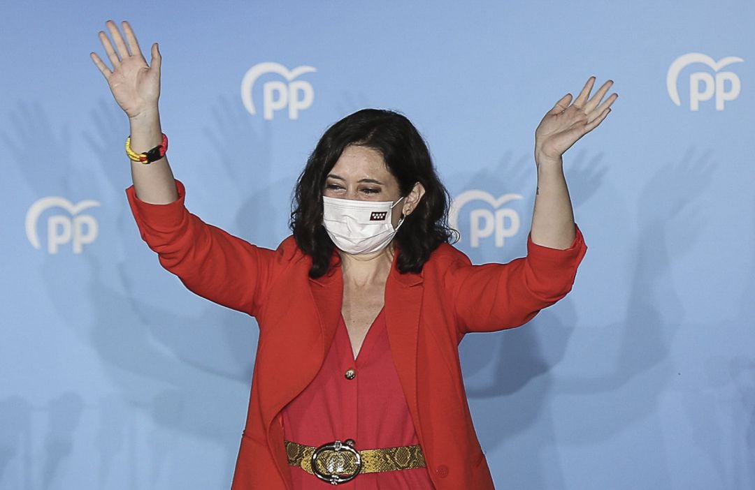 La presidenta de la Comunidad de Madrid y candidata a la reelección por el PP, Isabel Díaz Ayuso, saluda desde el balcón de la sede del partido