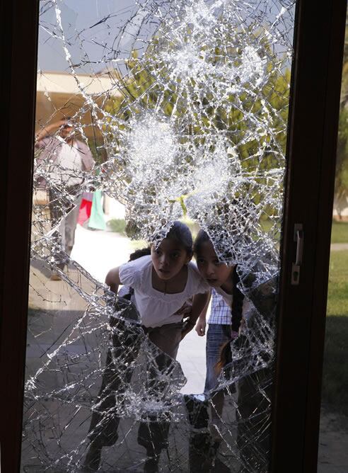 Unas niñas libias miran a través de un cristal roto perteneciente a la casa de Gadafi, en Bin Ashour en Trípoli.