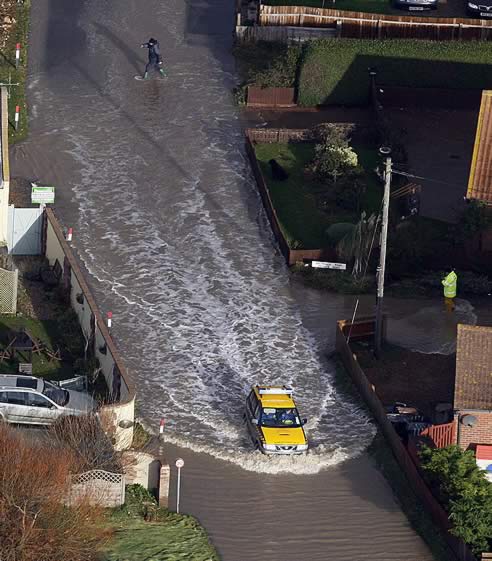 Un coche guardacostas conduce por una calle inundada en Walcott, cerca de Great Yarmouth