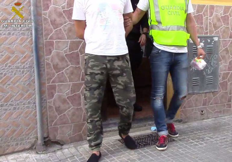 Imagen de un agente de la Guardia Civil con una persona detenida