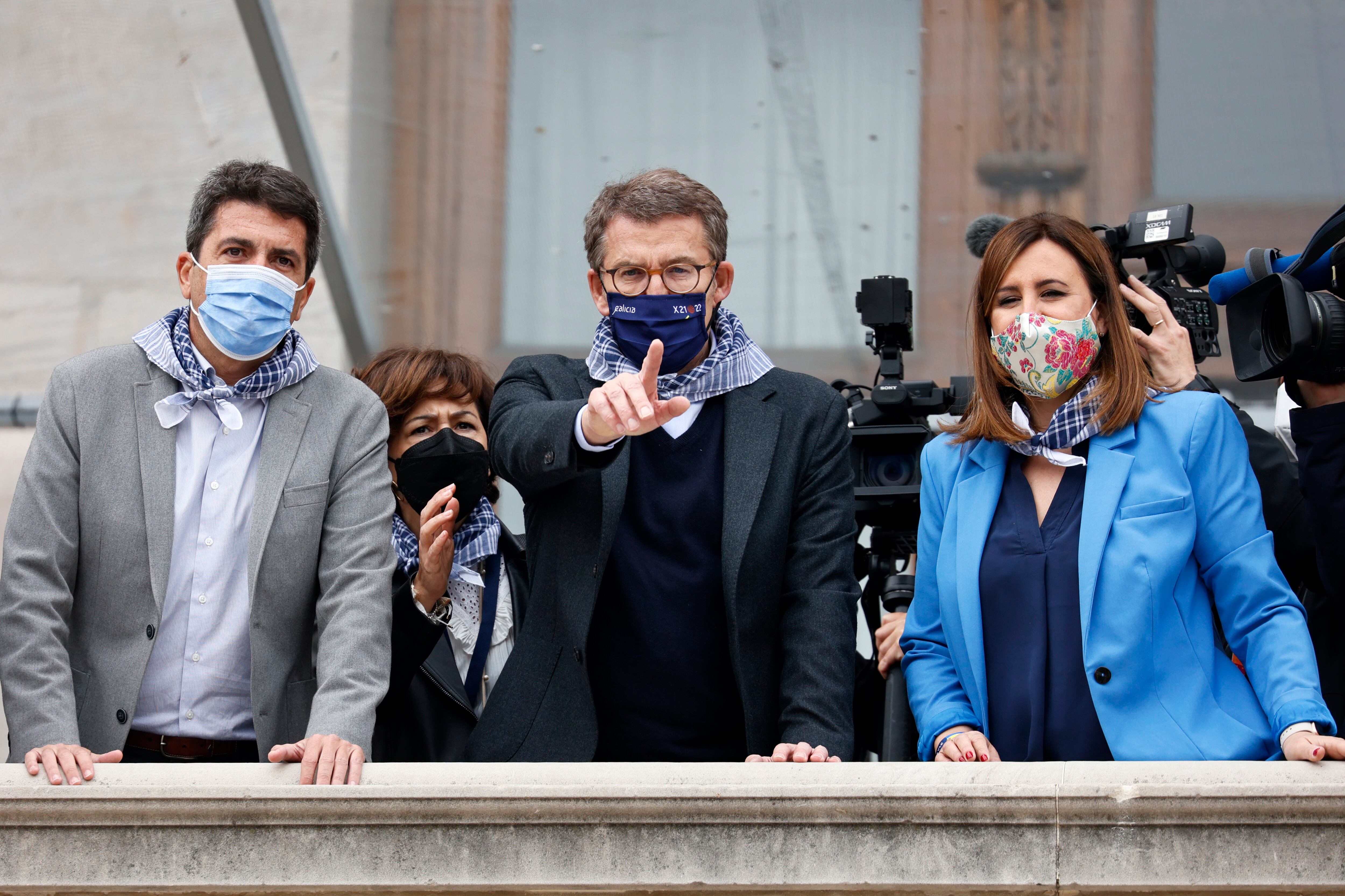 El presidente de la Xunta de Galicia y candidato único a la presidencia del PP, Alberto Núñez Feijóo, junto al presidente del PP de la Comunidad Valenciana, Carlos Mazón (i), y a la portavoz municipal del PP, María José Catalá, asisten a la mascletà de la plaza del Ayuntamiento.