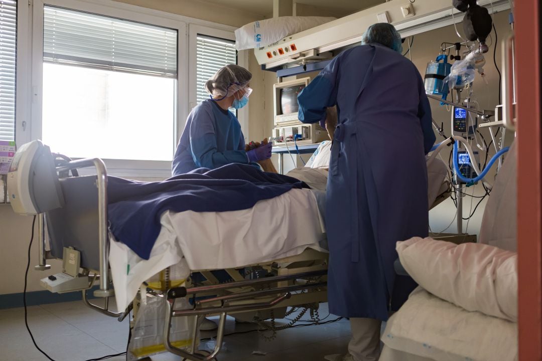 Dos sanitarias atendiendo a un paciente de COVID-19 en la UCI. 