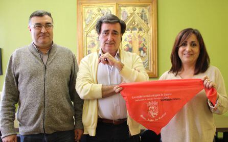 La concejal de Turismo muestra un pañuelo rojo con la palabra &#039;Internacional&#039; escrita a mano. Acompañada del alcalde de Cuéllar y el concejal de Festejos