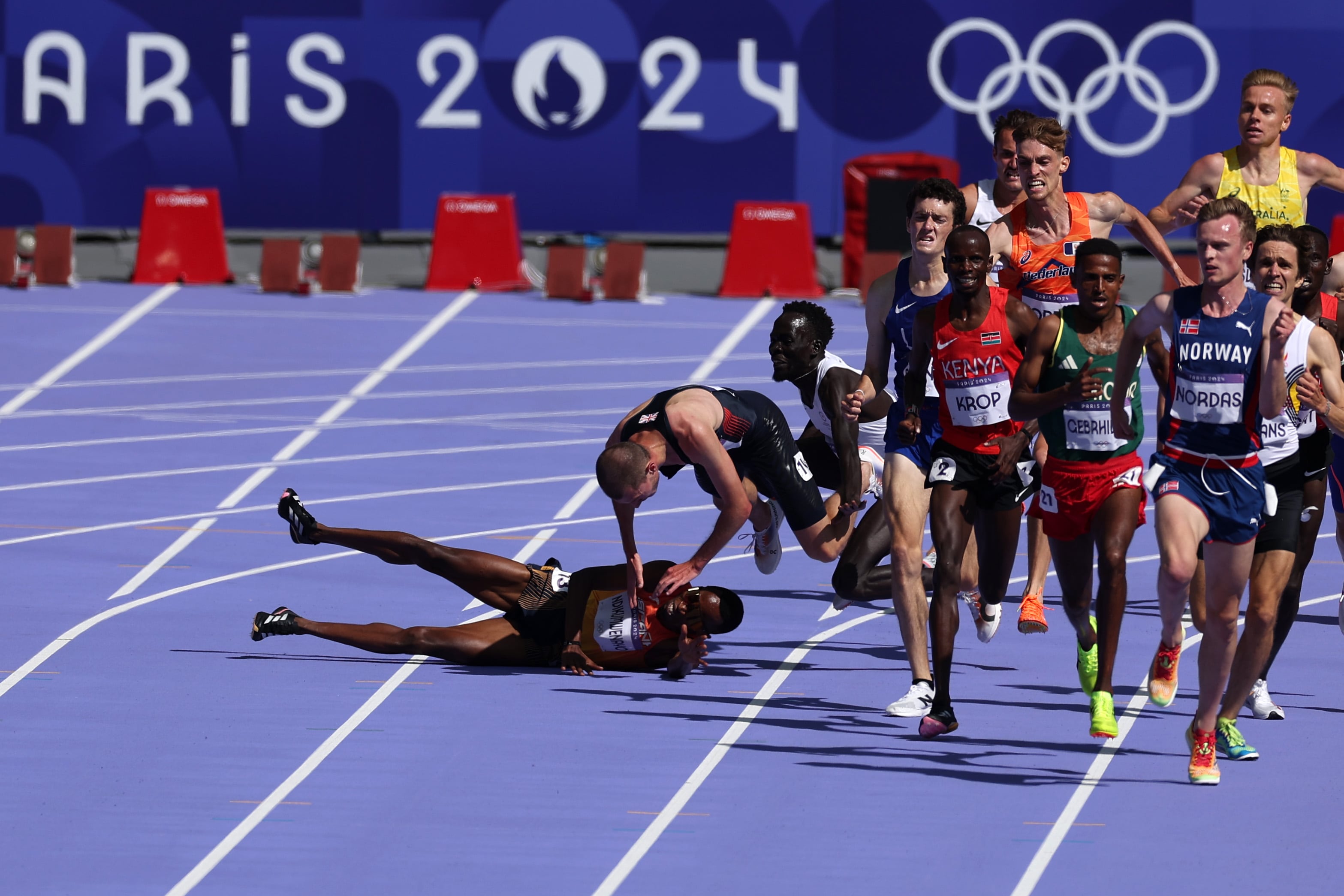 Thierry Ndikumwenayo cae al suelo tras un toque previo a la recta final del 5.000m