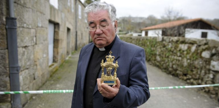 El párroco Antonio Gómez, amigo de Adolfo E.M., sostiene en sus manos una réplica de la Virxe do Cristal