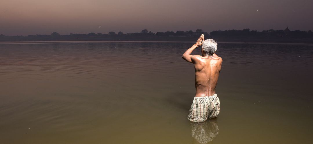 Un hombre reza en el río Ganges