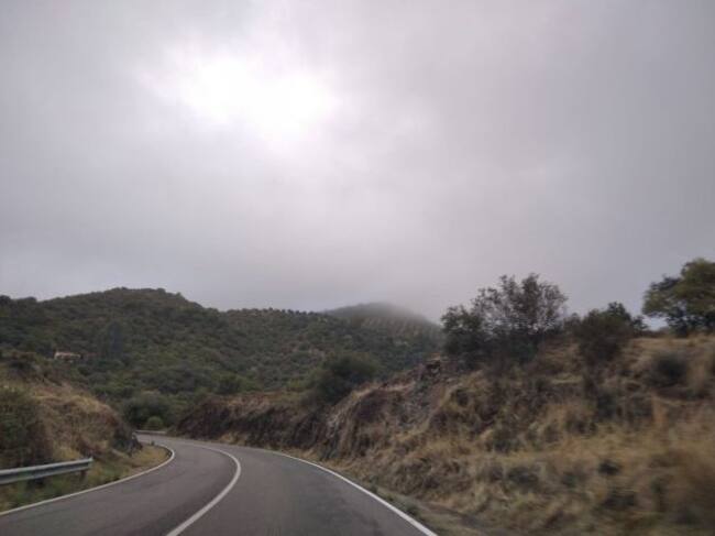 Entre la niebla, arriba a la derecha, la finca de olivar de sierra en el término municipal de Córdoba.