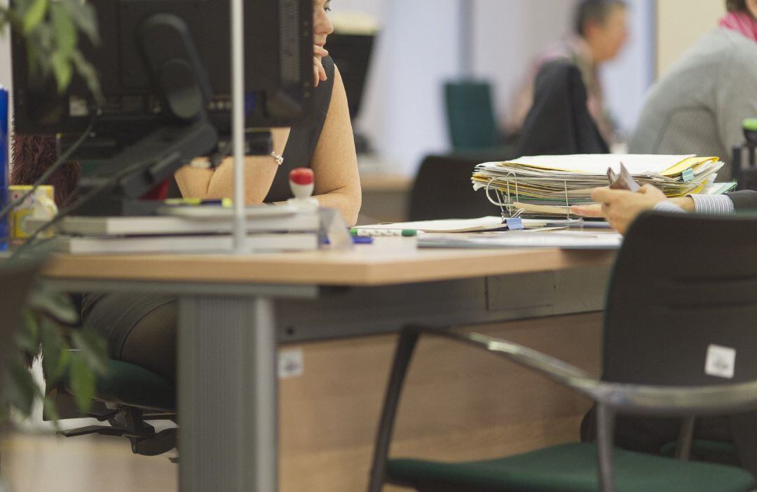 Un persona atiende a otra en una oficina de Empleo.