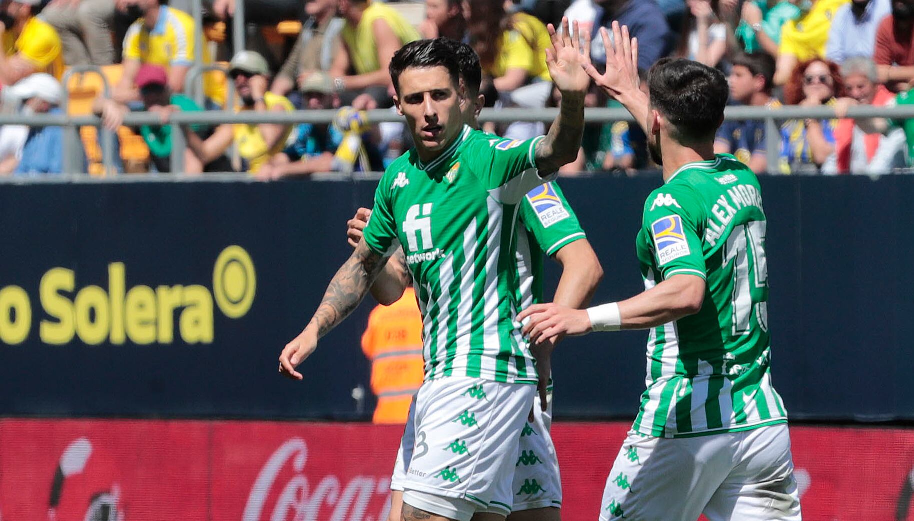 CÁDIZ, 09/04/2022.- El delantero del Betis Tello celebra con su compañero, Alex Moreno su gol ante el Cádiz durante el partido de LaLiga que enfrenta al Cádiz CF y al Real Betis en el Estadio Nuevo Mirandilla este sábado. EFE/Román Ríos.
