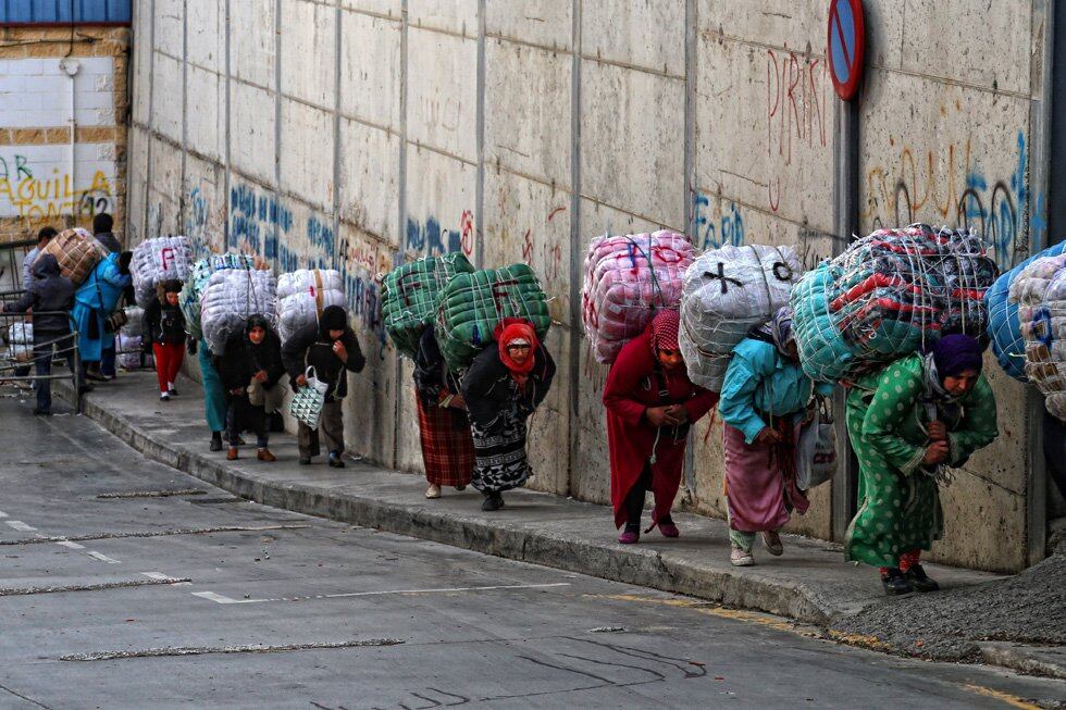 Las porteadoras se dirigen desde las naves de &quot;El Tarajal&quot; hasta el paso de &quot;El Biutz&quot;.