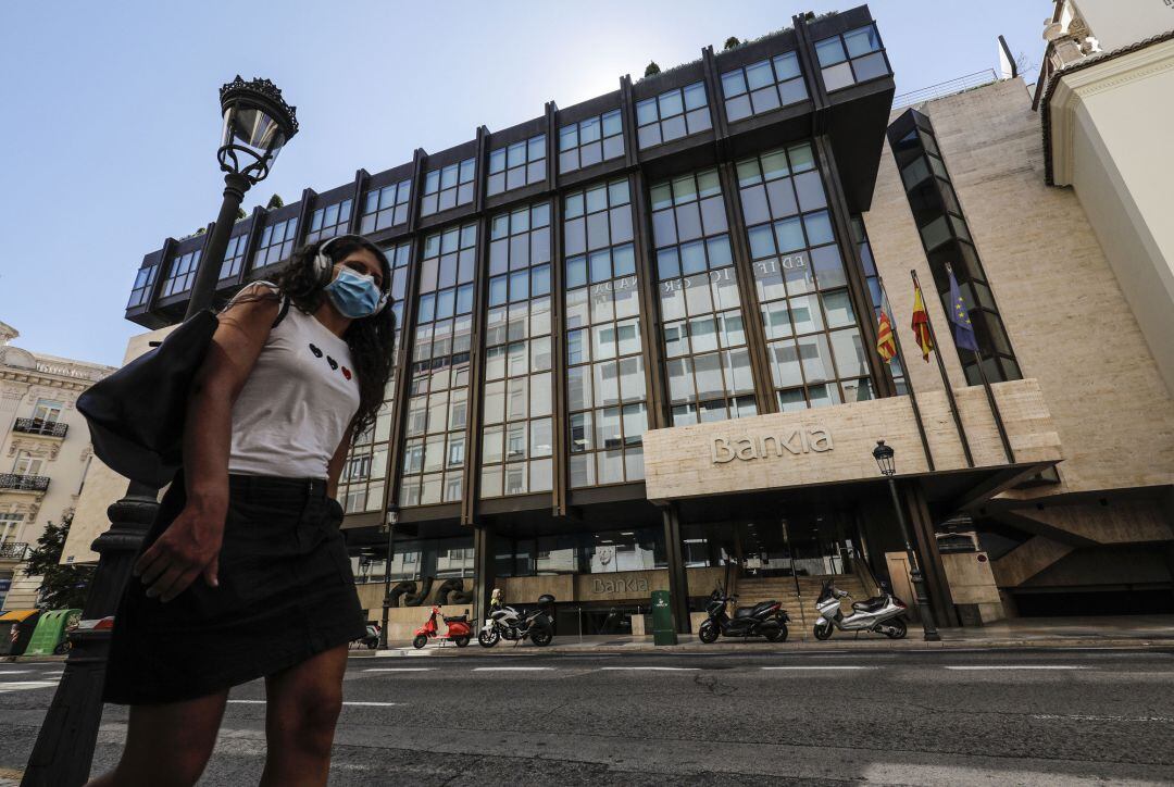 Una joven pasa por las inmediaciones de la sede de Bankia en Valencia