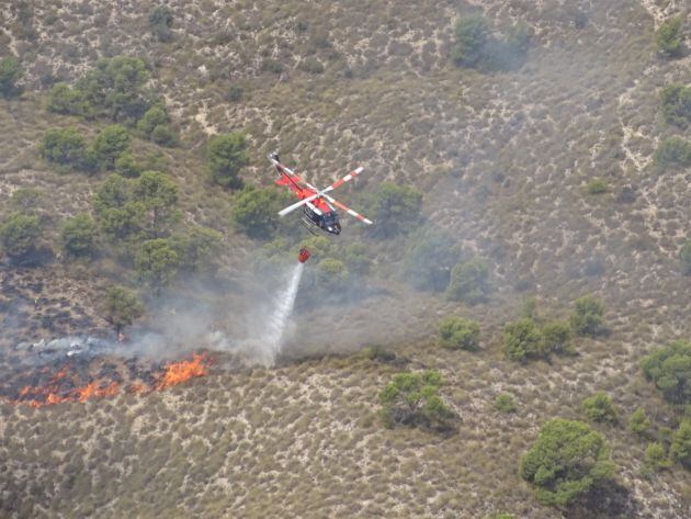 Un helicóptero sofoca las llamas del incendio forestal de Macisvenda en Abanilla