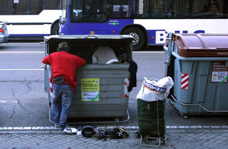 Una persona rebusca en un contenedor de basura en una calle de Valladolid