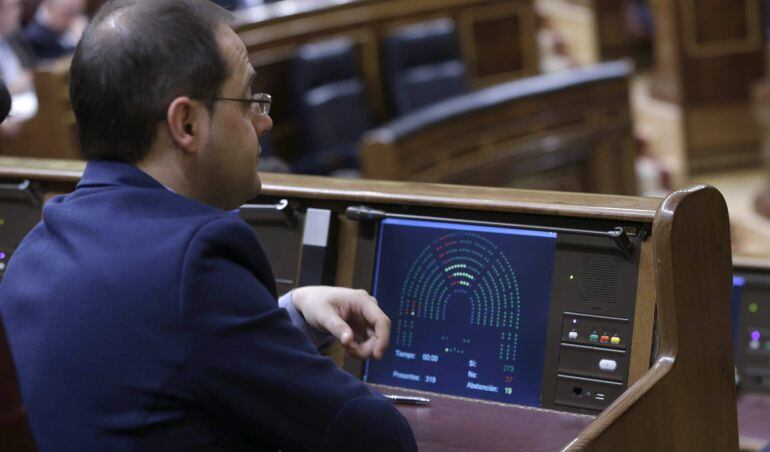 El diputado y secretario de Organización del PSOE, César Luena, observa el panel de votaciones durante el pleno del Congreso.