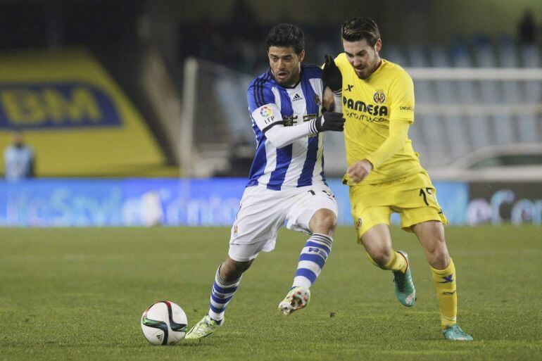  El delantero mexicano de la Real Sociedad, Carlos Vela (i), lucha el balón con Moi Gómez, del Villarreal, durante el partido de vuelta de los octavos de final de la Copa del Rey que se disputa esta noche en Anoeta. 