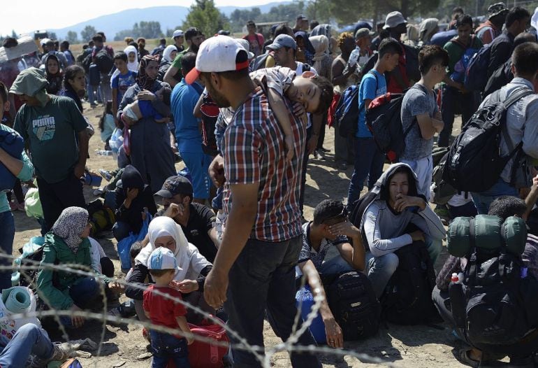 VAS21 GEVGELIJA (MACEDONIA) 28/08/2015.- Inmigrantes esperan en el paso fronterizo de Macedonia y Grecia cerca de Gevgelija hoy, 28 de agosto de 2015. Mientras los países de la Unión Europea discuten, Europa está a un paso de contabilizar las 300.000 lleg