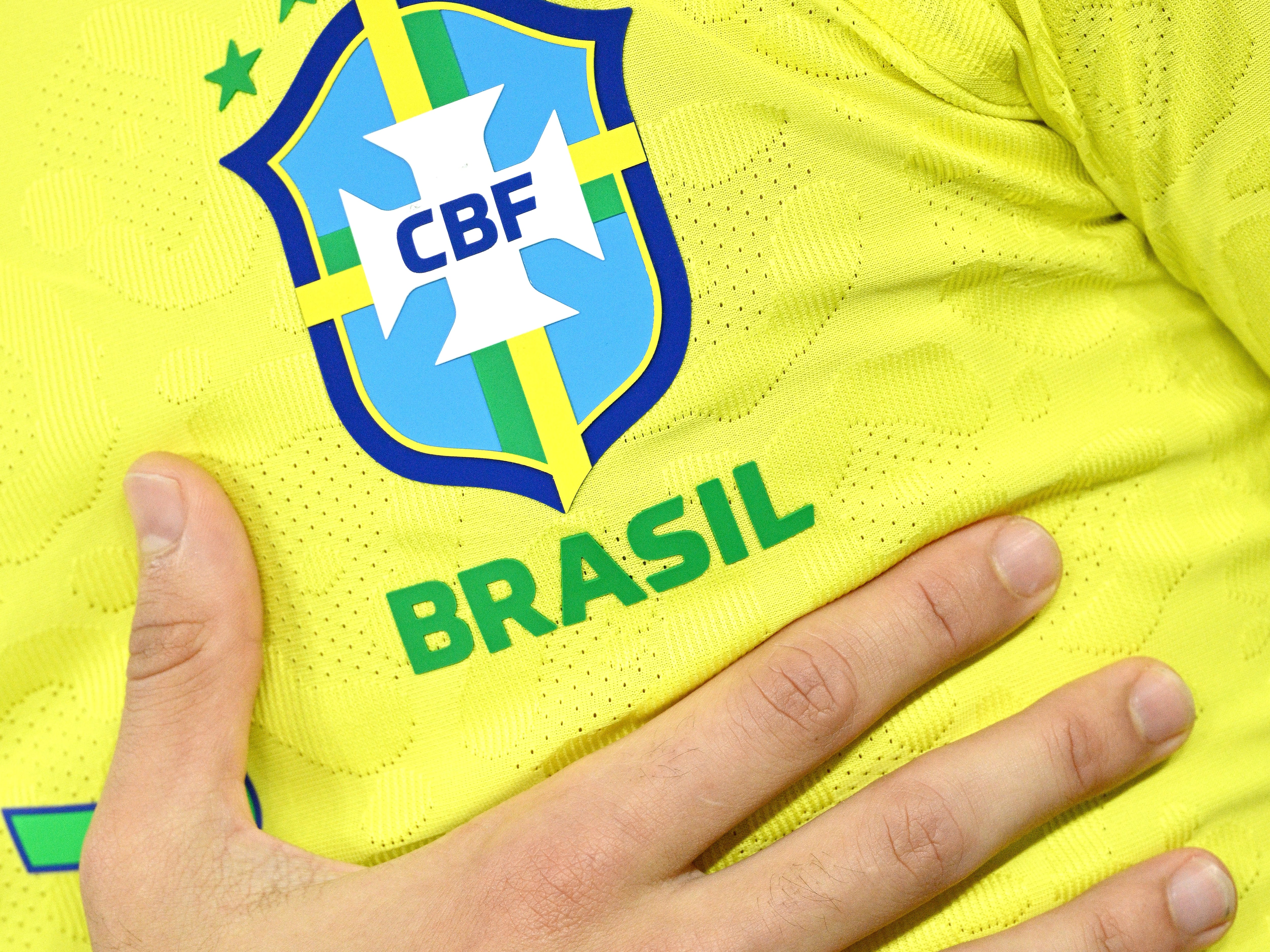 Un jugador del Brasil se toca el escudo durante el himno