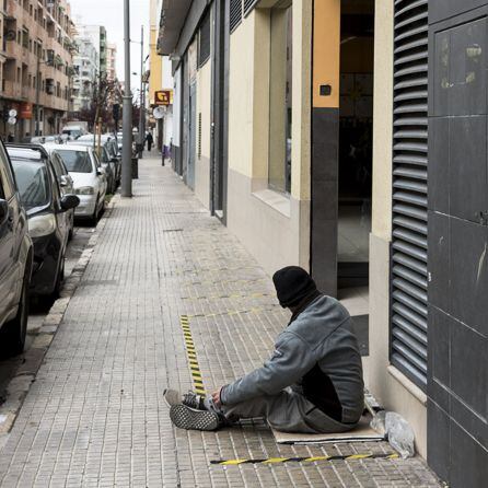 Una persona pide a las puertas de un supermercado en Gandia