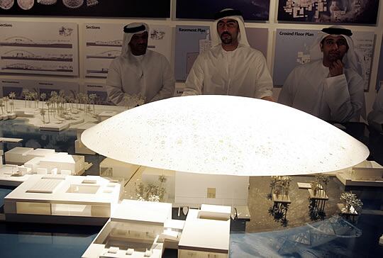 'NUEVO LOUVRE'. Varias personas miran la maqueta de la sede del museo Louvre que se abrirá en el emirato de Abu Dabi.