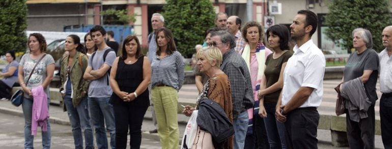 Algunos vecinos del municipio de Ferrol, durante el minuto de silencio guardado hoy en las puertas del Ayuntamiento en símbolo de duelo por la muerte de un joven que participaba ayer en un curso de surf en la playa de Esmelle de Ferrol.