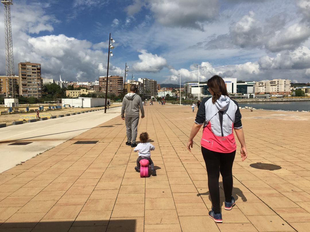 Niña pequeña juega, su madre la sigue.