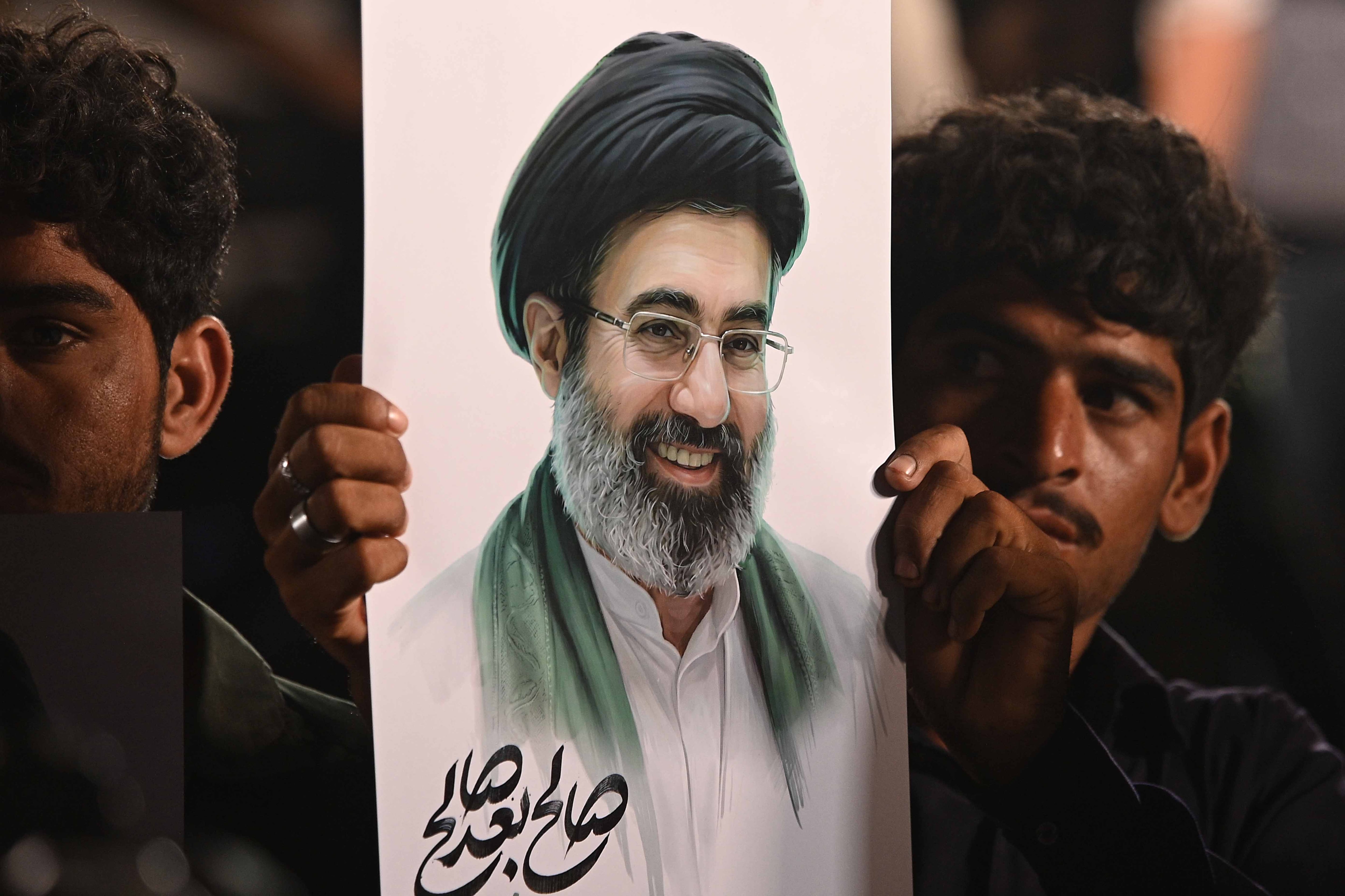 El líder supremo de Irán, Mojtaba Jameneí, en una pancarta sostenida por un ciudadano iraní tras el anuncio del alto el fuego entre Irán y Estados Unidos.