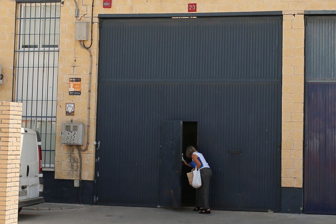 Una mujer se asoma a la puerta de la fábrica de &#039;Magrudis&#039; en Sevilla