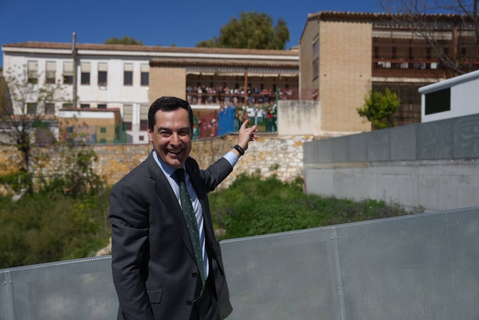 El presidente de la Junta, Juan Manuel Moreno, señala al alumnado del colegio 'Jesús María' durante su visita a Jaén.